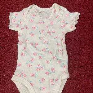 Cute newborn onesie t-shirt; white with pink flowers. Snaps on bottom.